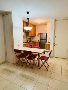 een keuken met een tafel, stoelen en een koelkast bij Apartment with a private backyard in Los Molles