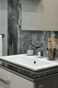 un bagno con un lavandino bianco e uno specchio di Ladi House a Nola