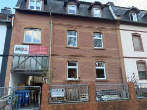 a large brick building with windows and a balcony at M-Suites - Near Frankfurt Airport in Hattersheim