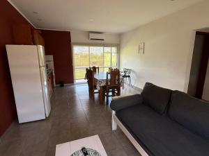 ein Wohnzimmer mit einem Sofa und eine Küche mit einem Tisch in der Unterkunft La casita de Isa in Gualeguay