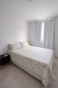 1 Schlafzimmer mit einem Bett mit Blumenbettdecke und einem Fenster in der Unterkunft Refúgio com lazer completo em Pium RN in Parnamirim + 41 Fotos
