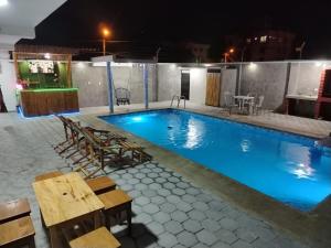 Oasis de Laura في أتاكاميس: مسبح في الليل مع كراسي وطاولة