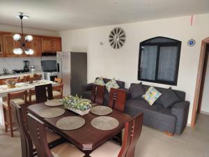 Oasis de Laura في أتاكاميس: مطبخ وغرفة معيشة مع طاولة وأريكة