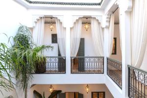 Blick aus dem zweiten Stock eines Gebäudes mit weißen Säulen in der Unterkunft Riad Sumud in Marrakesch