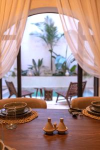 ein Holztisch mit Tellern und Schüsseln darauf in der Unterkunft Riad Sumud in Marrakesch