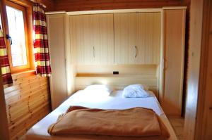 a small bedroom with a bed in a cabin at Les Rochettes Pluton 3 in La Roche-en-Ardenne