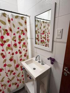 ein Badezimmer mit Waschbecken und Duschvorhang in der Unterkunft La casita de Isa in Gualeguay