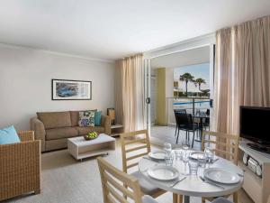 a living room with a couch and a table at Mantra Ettalong Beach in Ettalong Beach