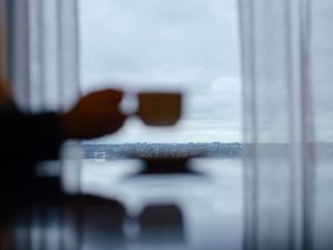 a person sitting at a table looking out a window at Mantra Melbourne Airport in Melbourne