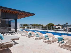 een rij ligstoelen op het dak van een gebouw bij The Johnson Brisbane - Art Series in Brisbane