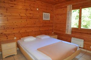 a bedroom with a bed in a wooden wall at Les Rochettes Vénus 5 in La Roche-en-Ardenne