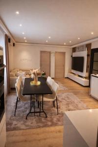 een woonkamer met een zwarte tafel en stoelen bij Tomorrowland Luxury Apartment in Boom