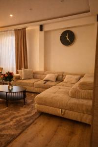 un soggiorno con 2 divani e un orologio sul muro di Tomorrowland Luxury Apartment a Boom