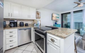a kitchen with white cabinets and a stove top oven at Island Winds West 777 in Gulf Shores