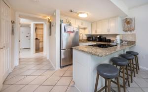 a kitchen with a stainless steel refrigerator and stools at Island Winds West 777 in Gulf Shores