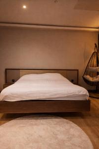 una camera da letto con un letto con lenzuola bianche e un tappeto di Tomorrowland Luxury Apartment a Boom Altre 7 foto