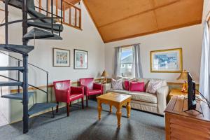 a living room with a couch and a spiral staircase at 4060 - Foxhole in Kitty Hawk Beach