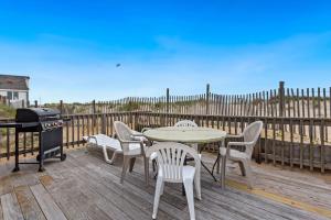 a patio with a table and chairs and a grill at 4060 - Foxhole in Kitty Hawk Beach