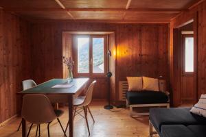 a living room with a table and a couch at Waterfall House - Art and Design, Ski, Hike, Swim in Mesocco