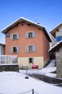 a large brick house with snow in front of it at Waterfall House - Art and Design, Ski, Hike, Swim in Mesocco