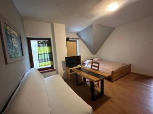 a room with a bed and a desk with a tv at Pod Kasztanem in Wisła