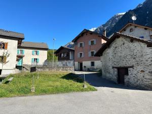 a group of buildings with mountains in the background at Waterfall House - Art and Design, Ski, Hike, Swim in Mesocco