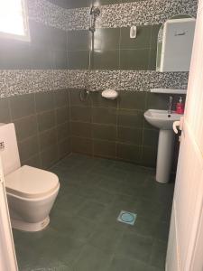 łazienka z toaletą i umywalką w obiekcie Amour Hostel w mieście As-Sib