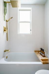 eine weiße Badewanne in einem Badezimmer mit Fenster in der Unterkunft Jungle House Luxury Stays - Columbus Downtown Short North in Columbus + 52 Fotos