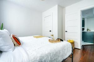 ein Schlafzimmer mit einem weißen Bett und einem Tisch darauf in der Unterkunft Jungle House Luxury Stays - Columbus Downtown Short North in Columbus