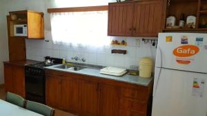 een keuken met een spoelbak en een koelkast bij Casa Punilla in Valle Hermoso