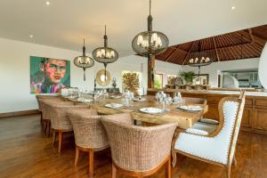 a dining room with a long table and chairs at Villa Naty in Canggu