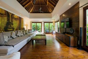 a living room with a couch and a tv at Villa Naty in Canggu