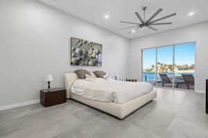 een witte slaapkamer met een bed en een groot raam bij Villa Stella in Burnt Store Marina +40 foto's