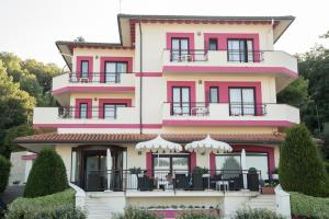 un edificio de color rosa y blanco con balcón en Hotel Levante en Fossacesia