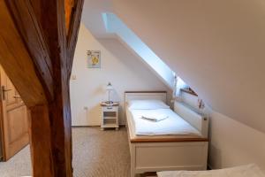 una piccola camera da letto con un letto in mansarda di Farma Basarovi a Prosečné