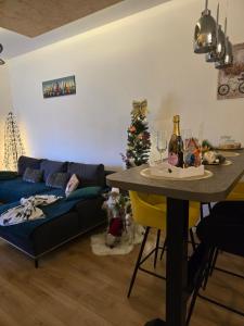 a living room with a couch and a table with a christmas tree at Apartman Marjanović Palić in Palić