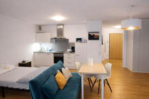 een woonkamer en keuken met een bank en een tafel bij Green Plants 24 7 Check In 4 Persons in Kelkheim