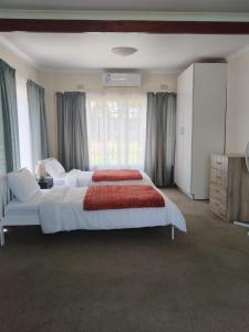 una camera da letto con un letto grande e una grande finestra di Greenstone Guesthouse a Muldersdrift Altre 58 foto