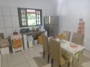 een keuken met een tafel met stoelen en een tafel en een keuken met een tafel bij Chácara da Vó na Natureza in Mogi das Cruzes
