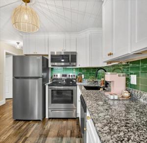 a kitchen with stainless steel appliances and green and white cabinets at Safety Harbor Motel in Safety Harbor