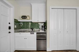 a kitchen with white cabinets and a silver dishwasher at Safety Harbor Motel in Safety Harbor +66 photos