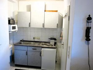 a small kitchen with a sink and white cabinets at Stadtzentrum , nähe Schloss in Klütz