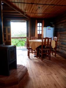 a living room with a table and chairs and a refrigerator at Cabaña Alcione in Capilla del Monte +13 photos