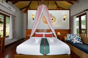 a bedroom with a bed with a mosquito net at PingChan Koh Phangan Beachfront Resort in Thong Nai Pan Yai
