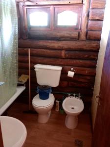 a bathroom with a toilet and a sink at Cabaña Alcione in Capilla del Monte