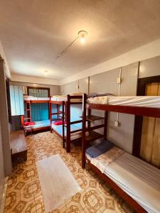 a room with three bunk beds and a rug at Maracujá Hostel in Paraty