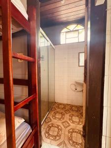 a bathroom with a bunk bed with a shower and a toilet at Maracujá Hostel in Paraty