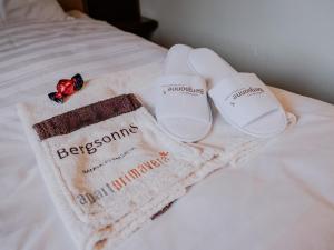 a pair of sandals and a towel on a bed at Apartment Bergsonne in Samnaun