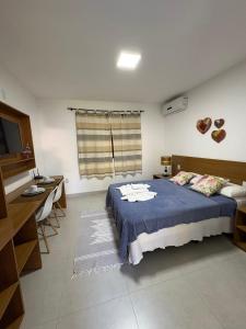 een slaapkamer met een bed, een bureau en een raam bij Pousada Jeito Bom de Viver in Caraíva