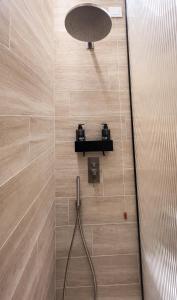 une douche avec un tuyau fixé à un mur carrelé dans l'établissement InCentro Boutique Apartments, à Macerata